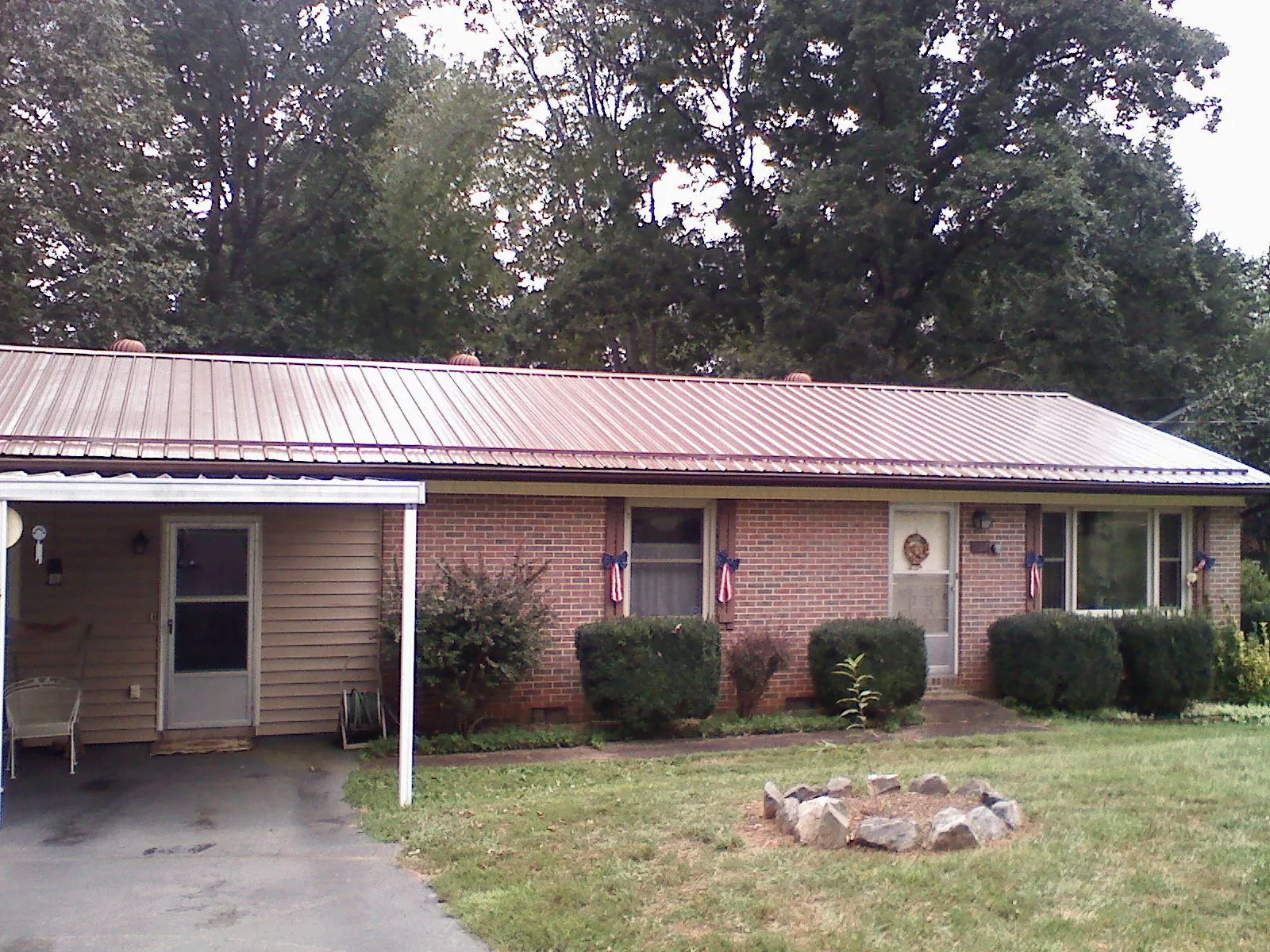 Bronze metal roof and carport on a brick ranch home — Roof Repair work by our crew in Yachats